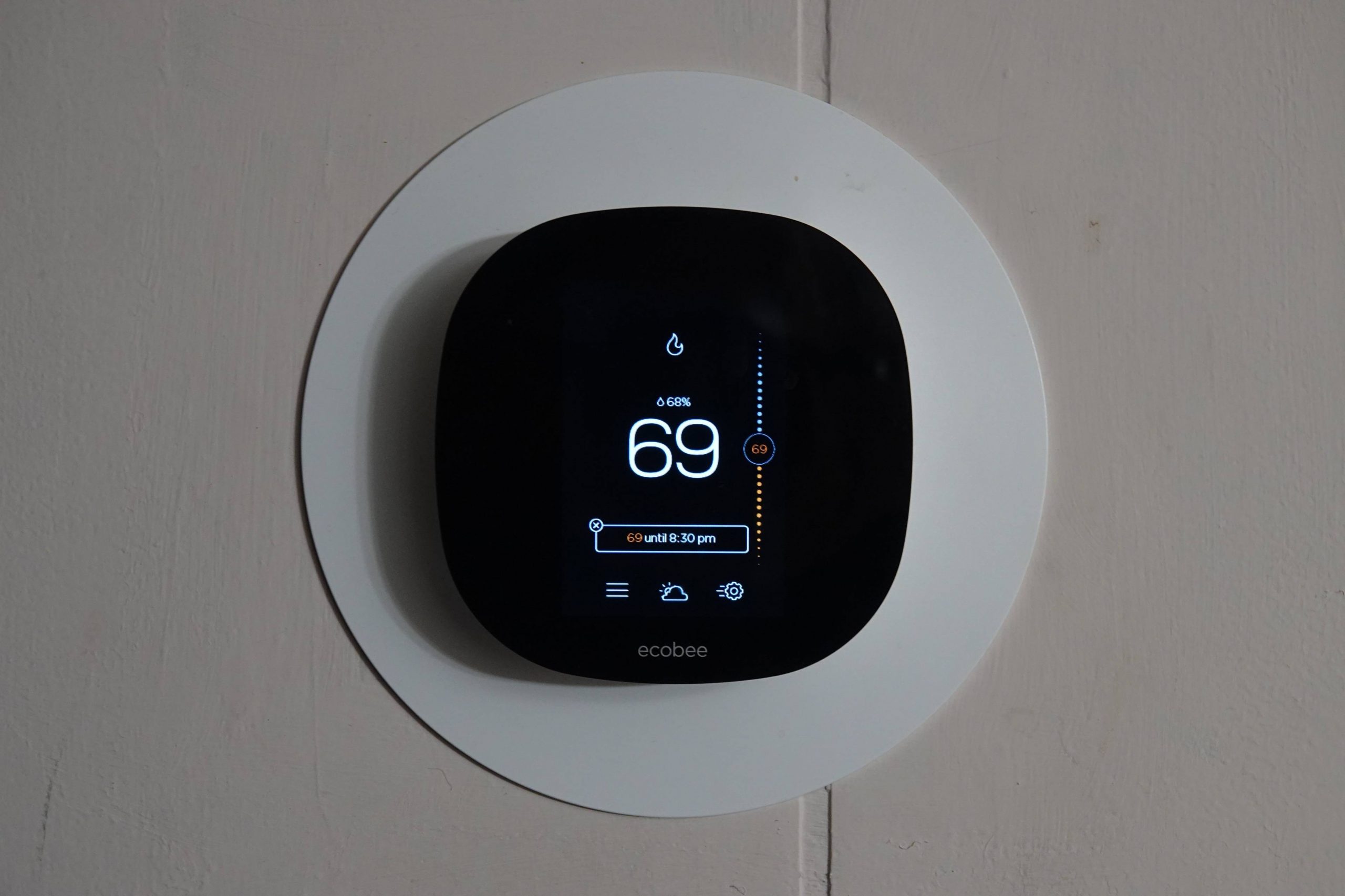 Smart thermostat mounted on a wall in an Ottawa home showing current temperature