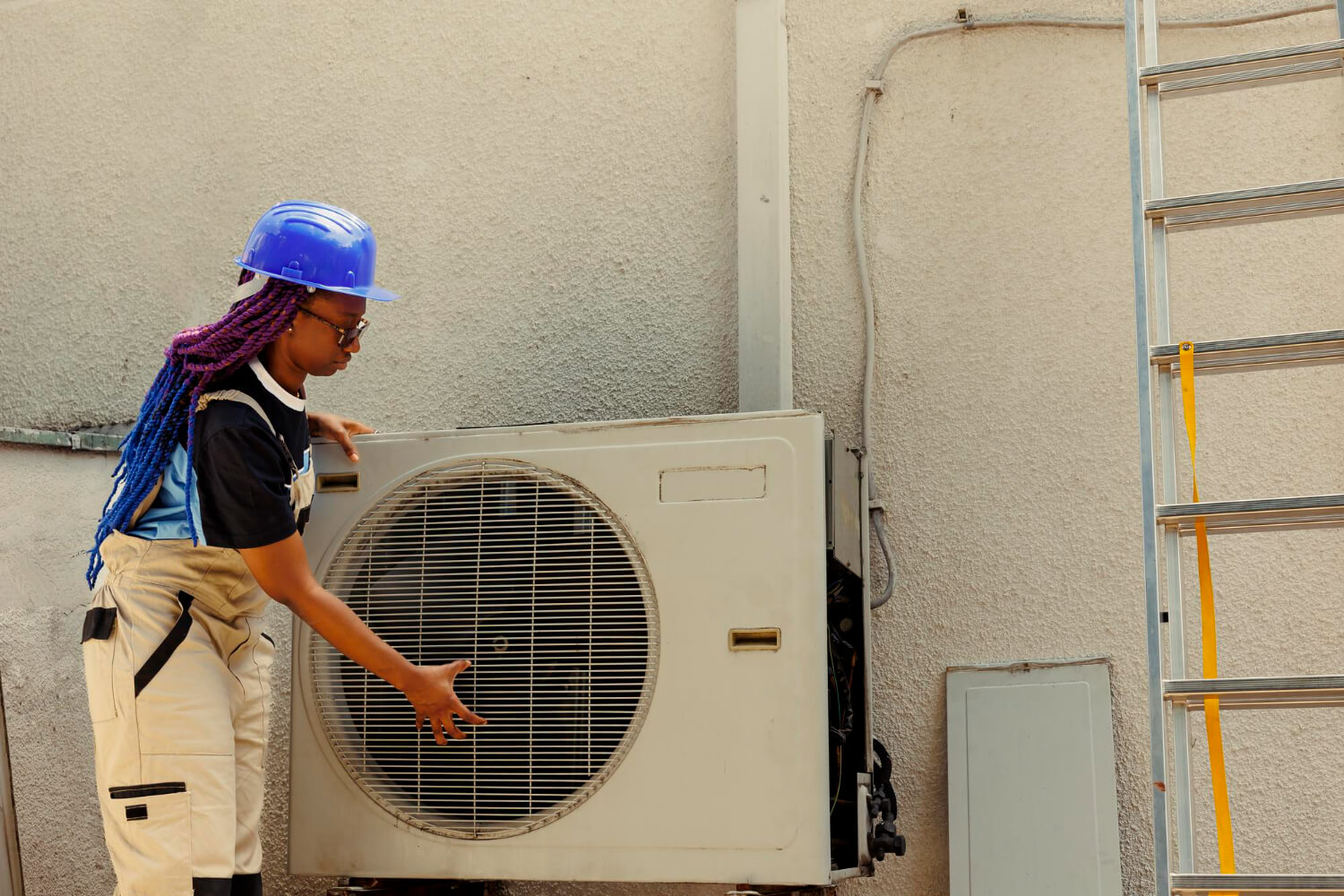 HVAC technician inspecting an outdoor air conditioner unit for leaks at an Ottawa home