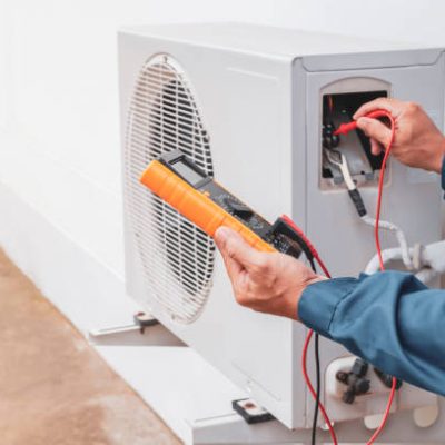 Air conditioner technician repairing central air conditioning system with outdoor tools